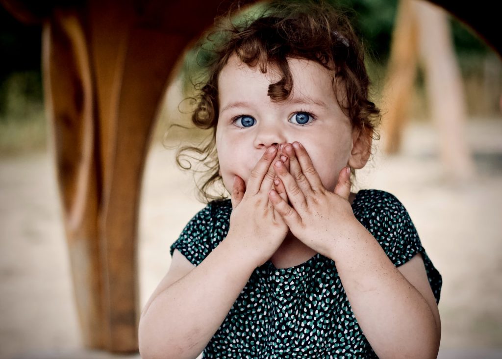 child covering mouth